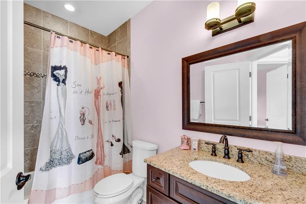 Bathroom featuring vanity, a shower with shower curtain, and toilet