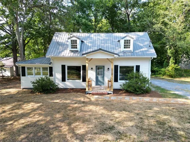 White siding exterior with a gray metal roof
