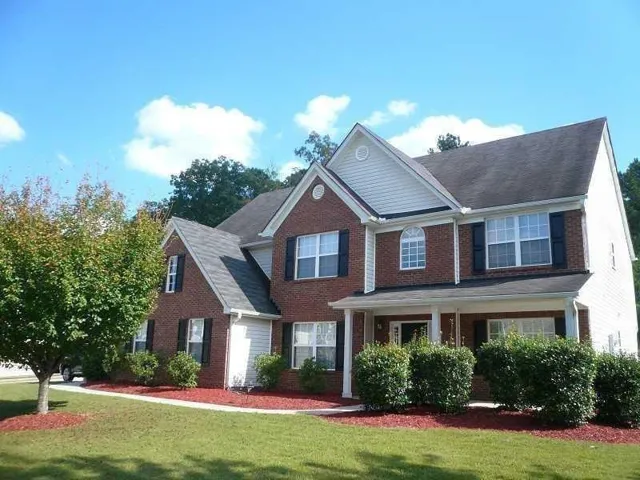 Brick and siding exterior with a covered front porch featuring white columns