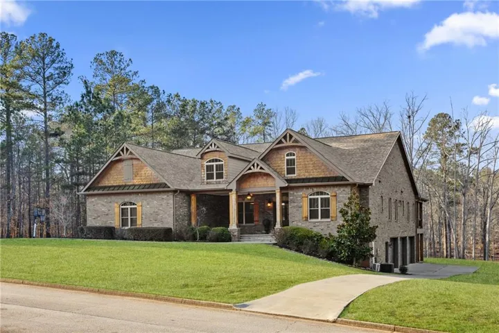View of front of property featuring a front lawn, brick siding, an attached garage, and concrete driveway