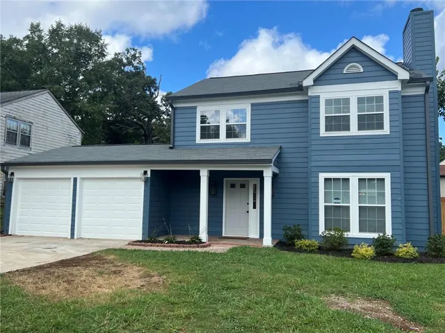 Two-story exterior with blue siding, white trim, and a covered front entry