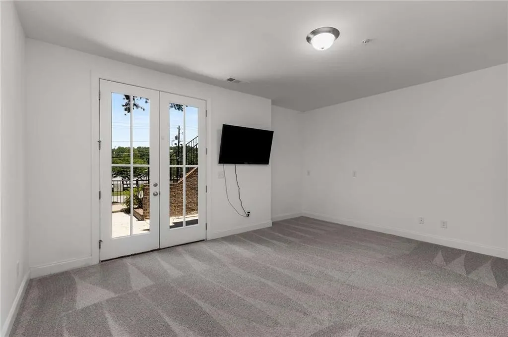 Empty room featuring french doors and carpet floors