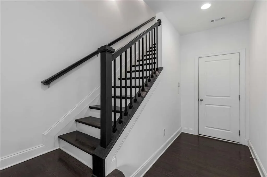 Stairway featuring wood finished floors and recessed lighting