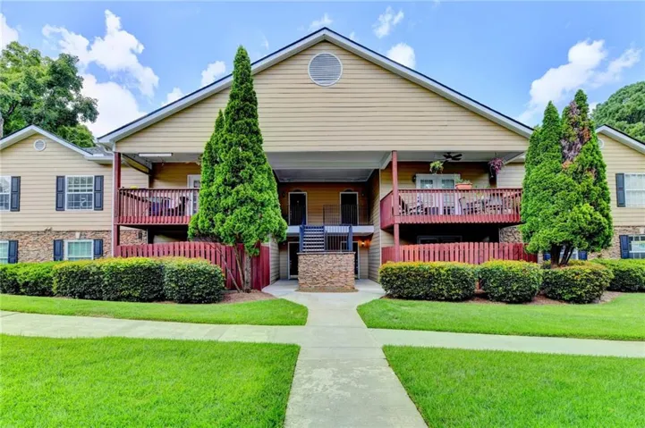 Multi-level exterior featuring siding and stone veneer, with multiple balconies and a ground-level patio