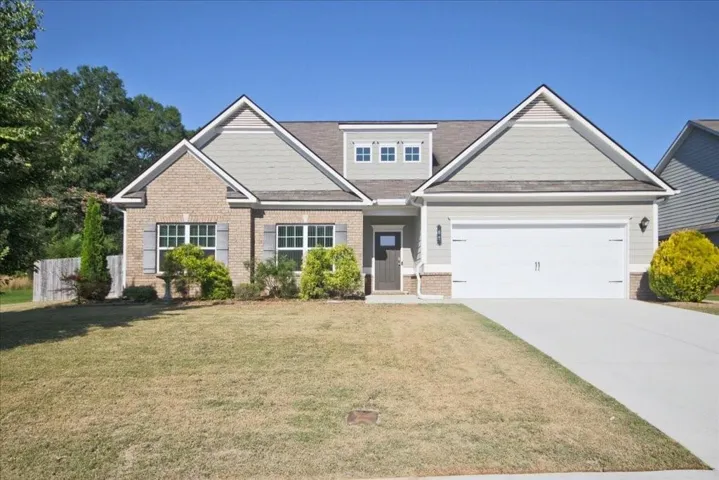 Single-story residence featuring a brick and siding exterior, a two-car garage, and a concrete driveway