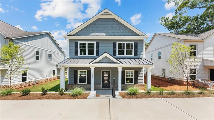 Two-story residence featuring a covered front porch, horizontal siding, shake siding, and a gabled roof