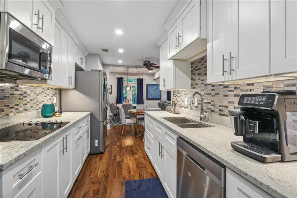 Kitchen with white cabinetry, appliances with stainless steel finishes, and sink