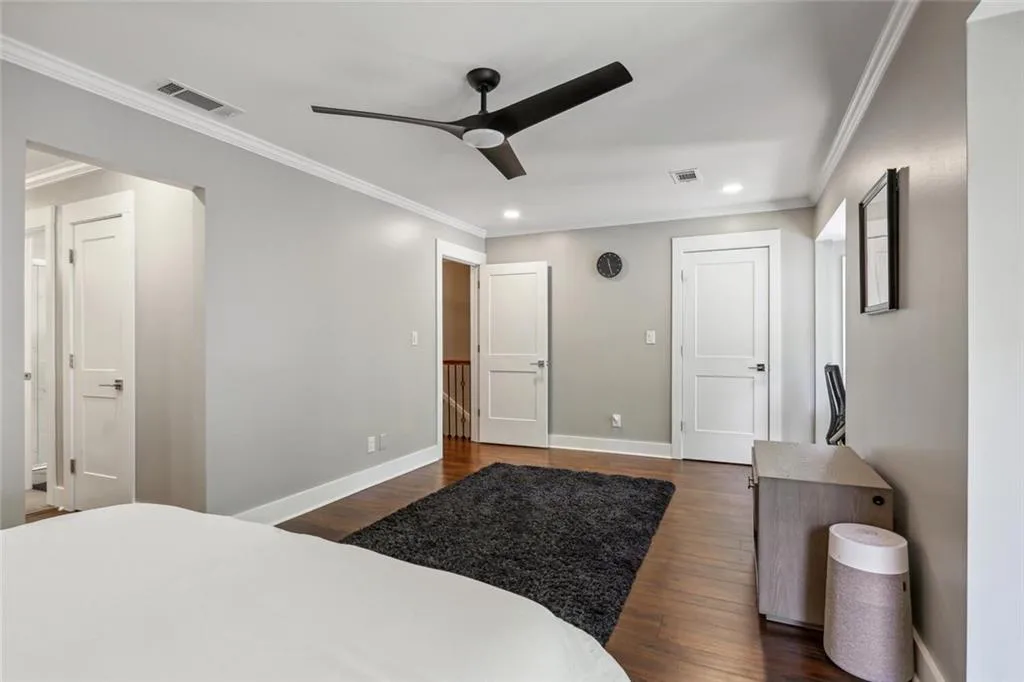 Bedroom with ornamental molding, dark hardwood / wood-style floors, and ceiling fan