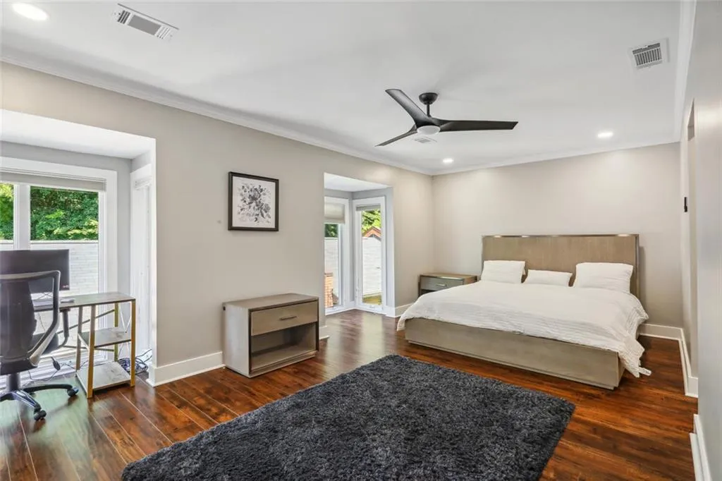 Bedroom with crown molding, ceiling fan, and dark hardwood / wood-style flooring