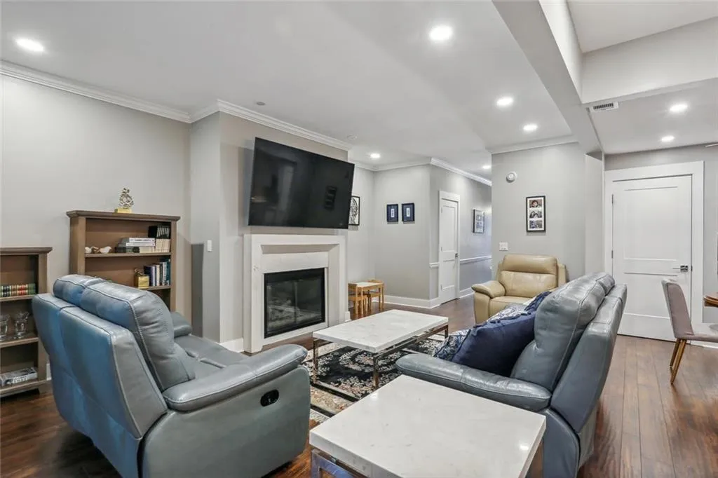 Living room featuring ornamental molding, a high end fireplace, and dark hardwood / wood-style flooring
