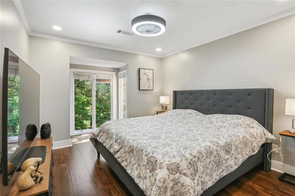 Bedroom with dark hardwood / wood-style flooring and ornamental molding