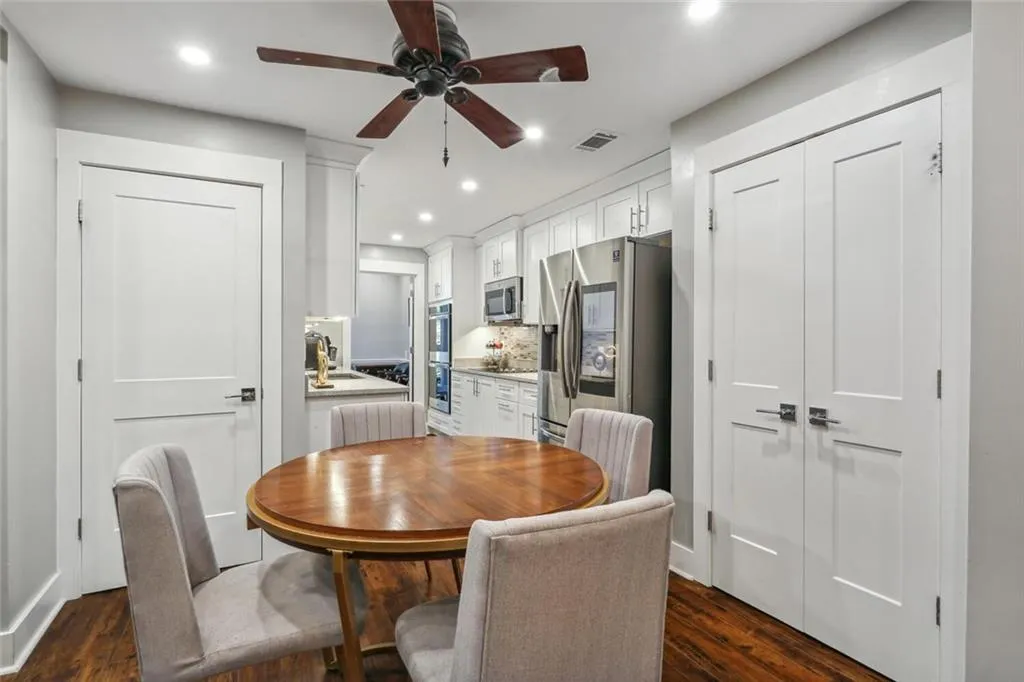 Dining area featuring dark wood-type flooring, ceiling fan, and sink