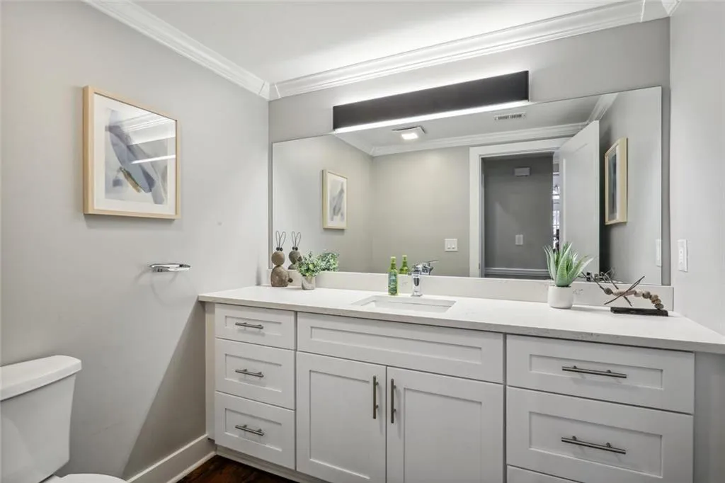Bathroom featuring vanity, crown molding, and toilet