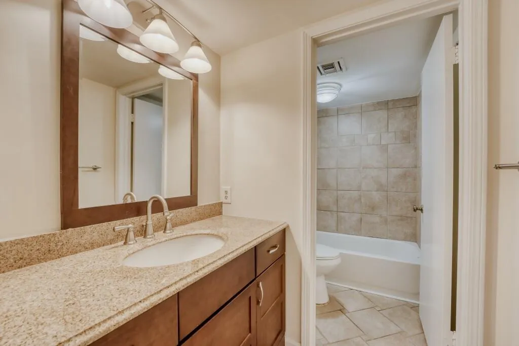 Guest bath featuring vanity and  tub/shower combination