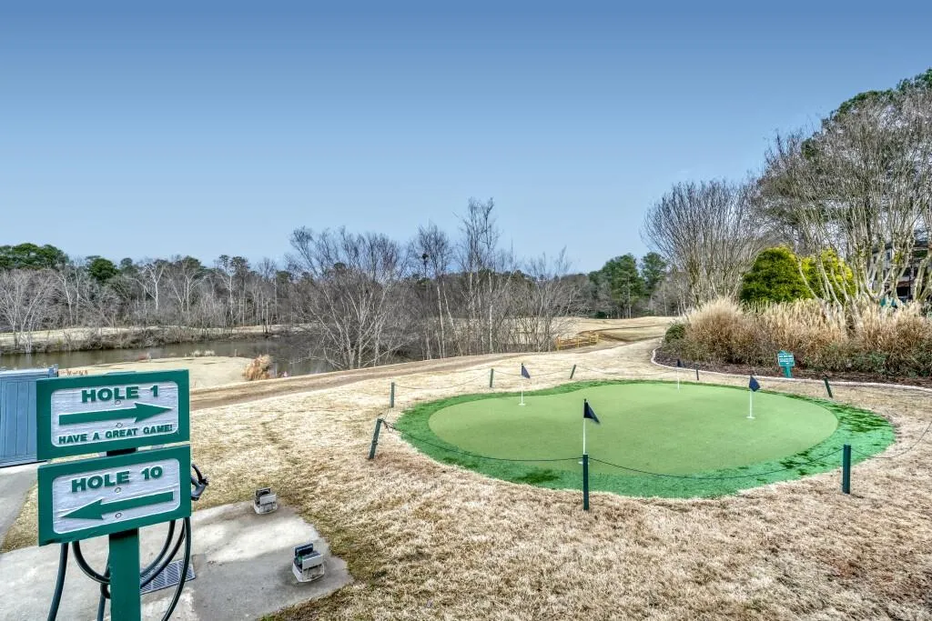 View of community with an area to practice putting and a water view