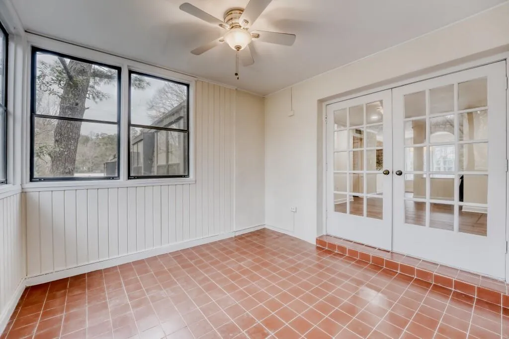 Sunroom with french doors, a ceiling fan, and light tile patterned flooring