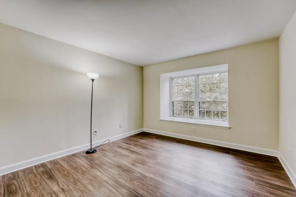 Guest bedroom with baseboards with wood finished floors
