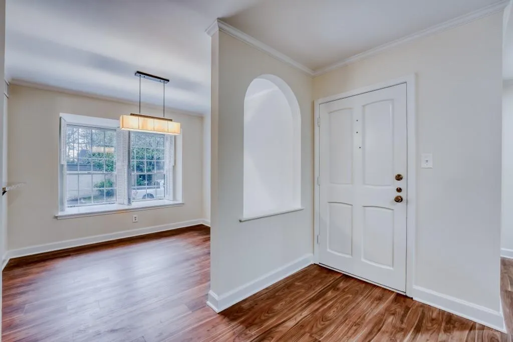 Foyer entrance featuring wood finished floors and ornamental molding