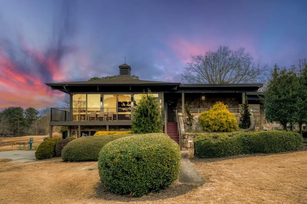 Back of property at dusk with stone siding