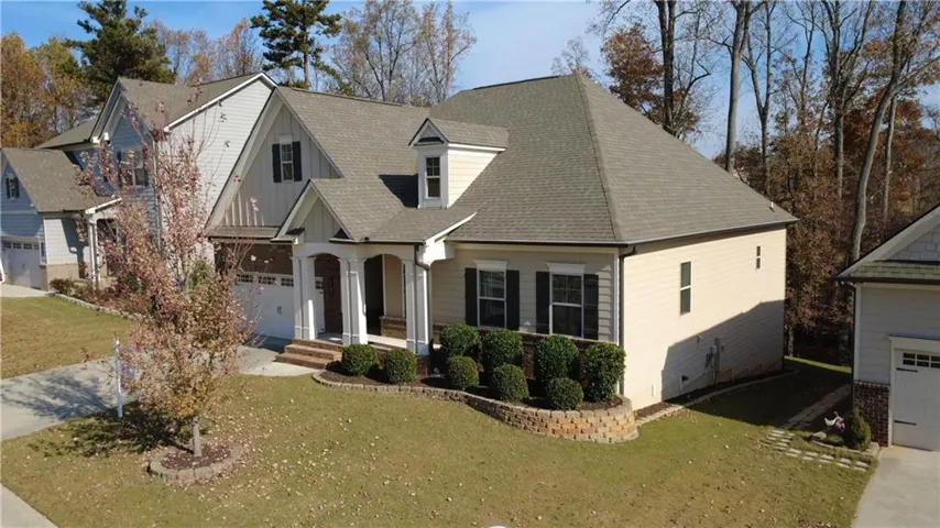 View of front of home featuring a garage, a front yard, roof with shingles, and concrete driveway