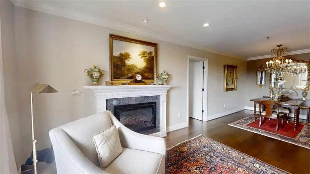 Living area with wood finished floors, crown molding, recessed lighting, a chandelier, and a fireplace