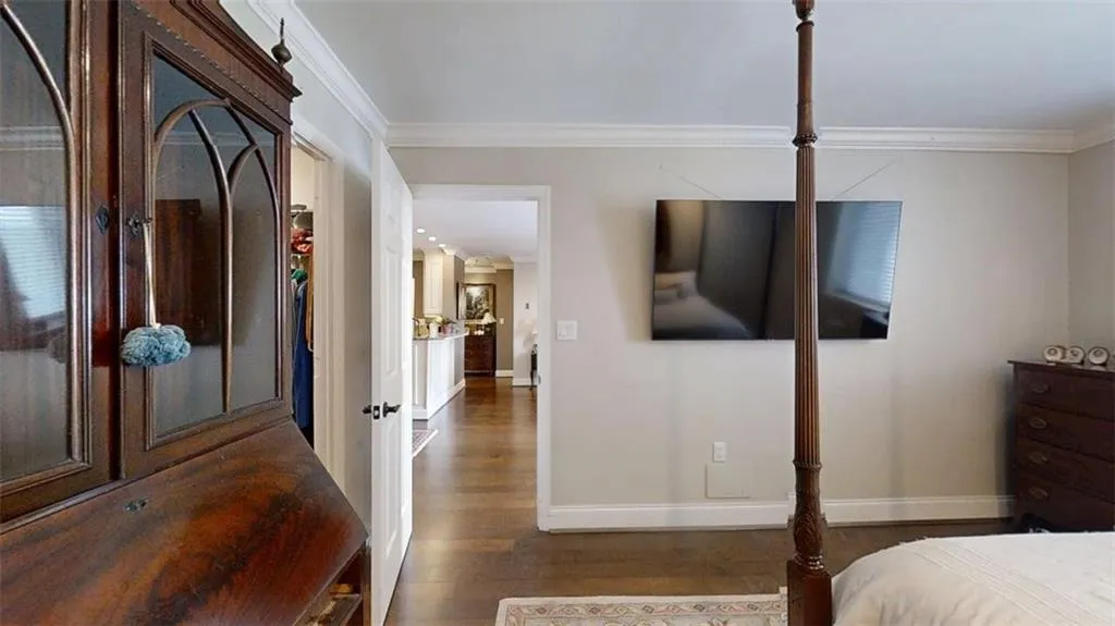 Bedroom with dark wood-style floors and ornamental molding