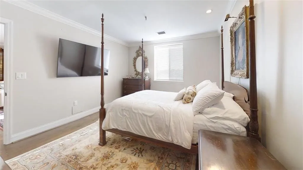 Bedroom featuring wood finished floors, crown molding, and recessed lighting