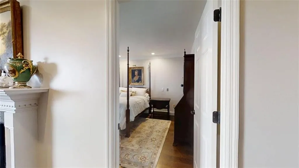 Corridor with wood finished floors, recessed lighting, and crown molding