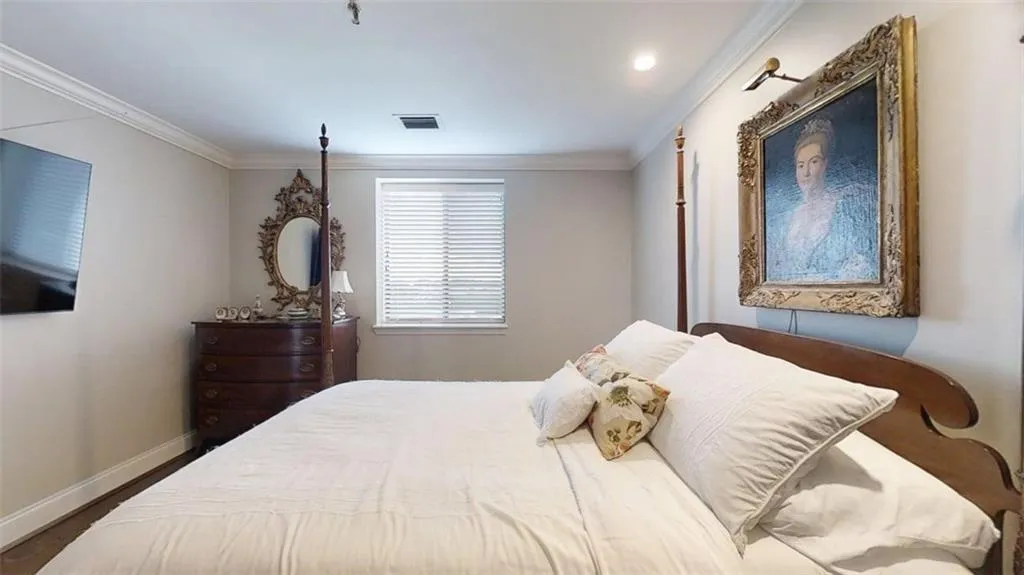 Bedroom with crown molding and wood finished floors