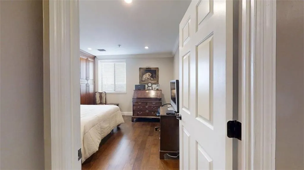 Bedroom with dark wood-type flooring, ornamental molding, and recessed lighting