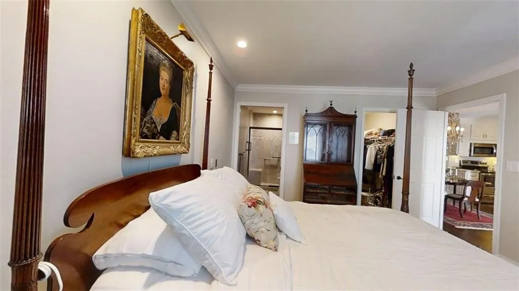 Bedroom with ornamental molding, a spacious closet, and ensuite bath