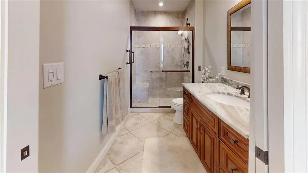 Bathroom featuring vanity, a shower stall, and tile patterned flooring