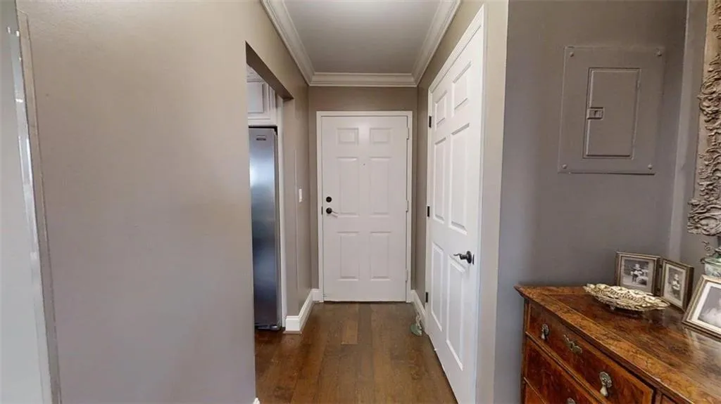 Hall with ornamental molding, dark wood-style flooring, and electric panel