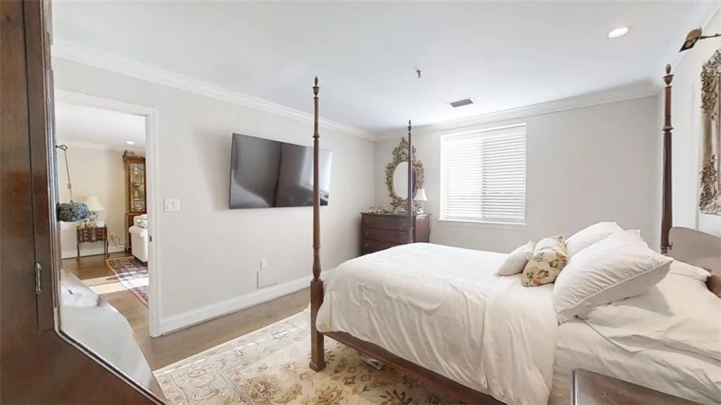 Bedroom with light wood-type flooring, ornamental molding, and recessed lighting