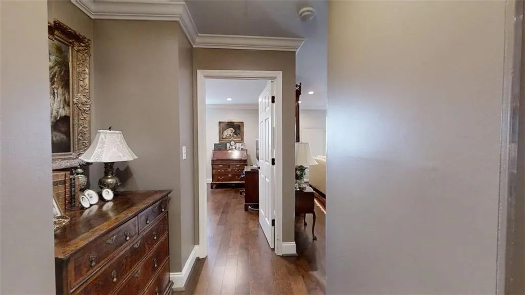 Hallway with dark wood finished floors and crown molding