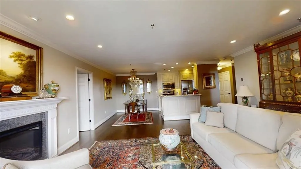 Living room with a chandelier, dark wood-type flooring, recessed lighting, a premium fireplace, and crown molding
