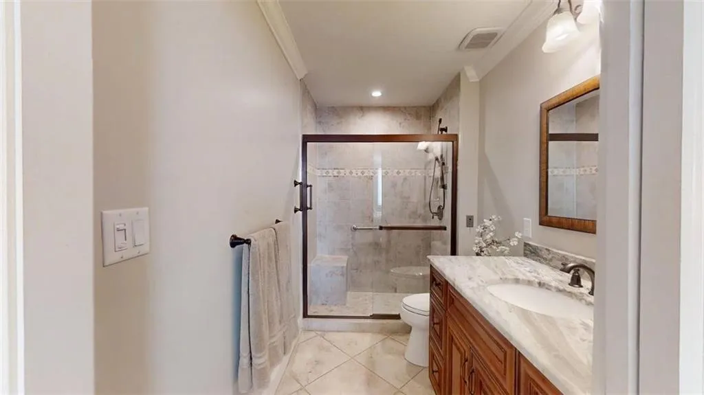 Bathroom with vanity, ornamental molding, a stall shower, and tile patterned flooring