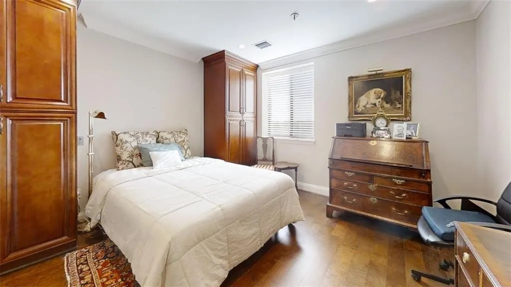 Bedroom with dark wood-style floors, ornamental molding, and recessed lighting