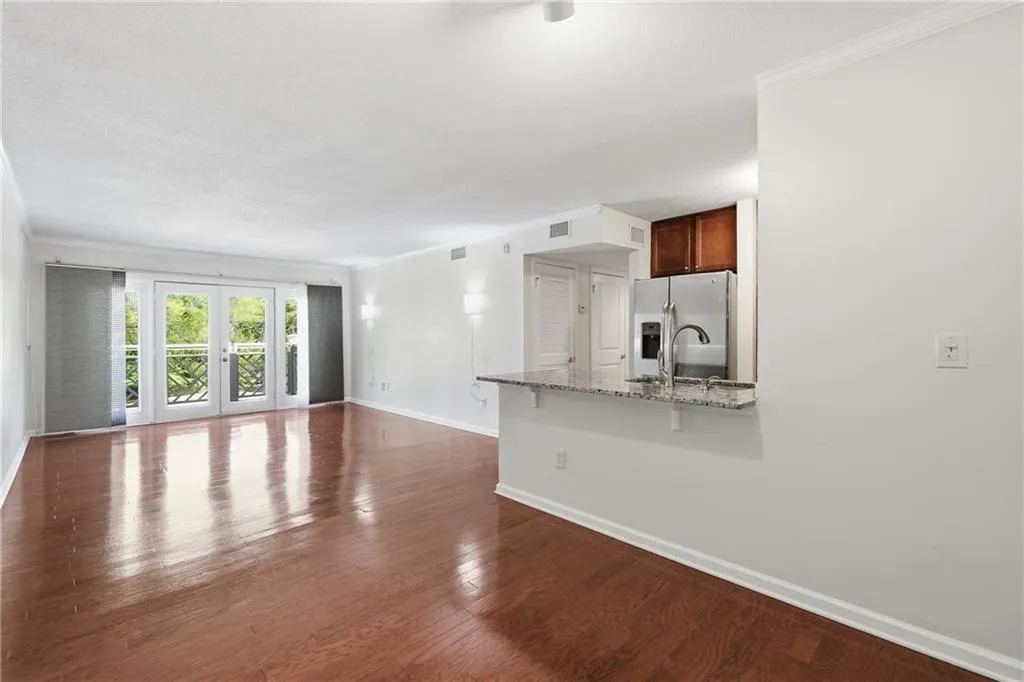 Unfurnished living room featuring french doors, crown molding, dark wood finished floors, and a textured ceiling