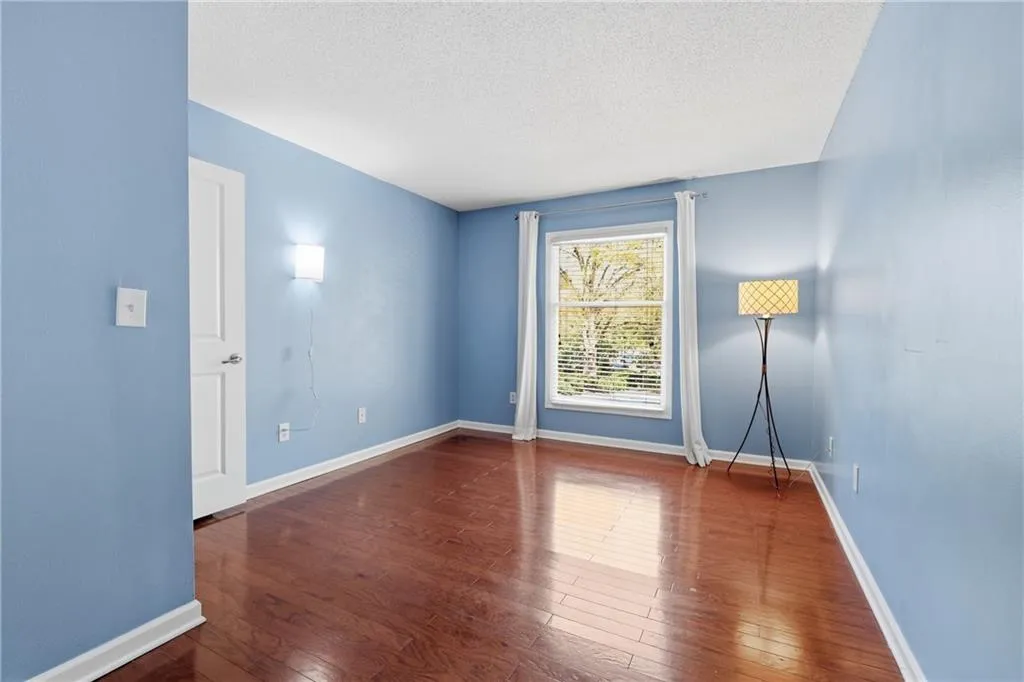 Empty room with dark wood-type flooring and a textured ceiling