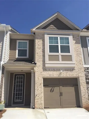 View of front of house with a garage, driveway, and brick siding