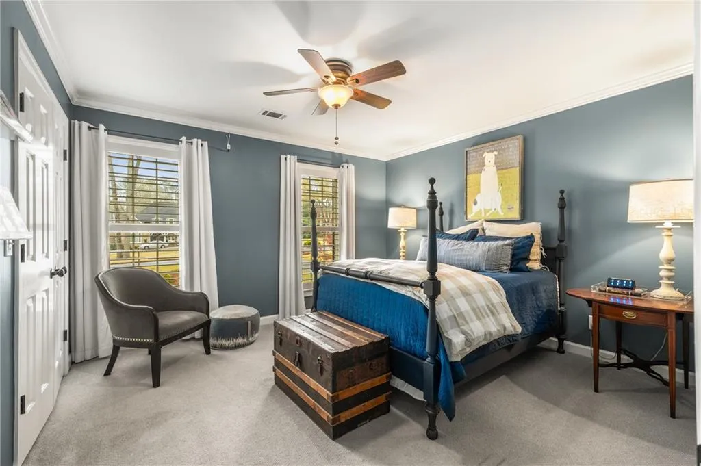 Bedroom featuring visible vents, multiple windows, crown molding, and light carpet