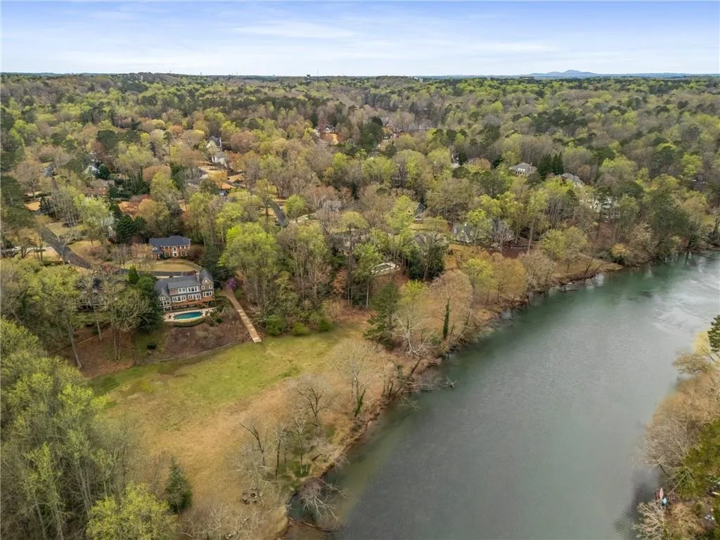 Bird's eye view featuring a wooded view and a water view