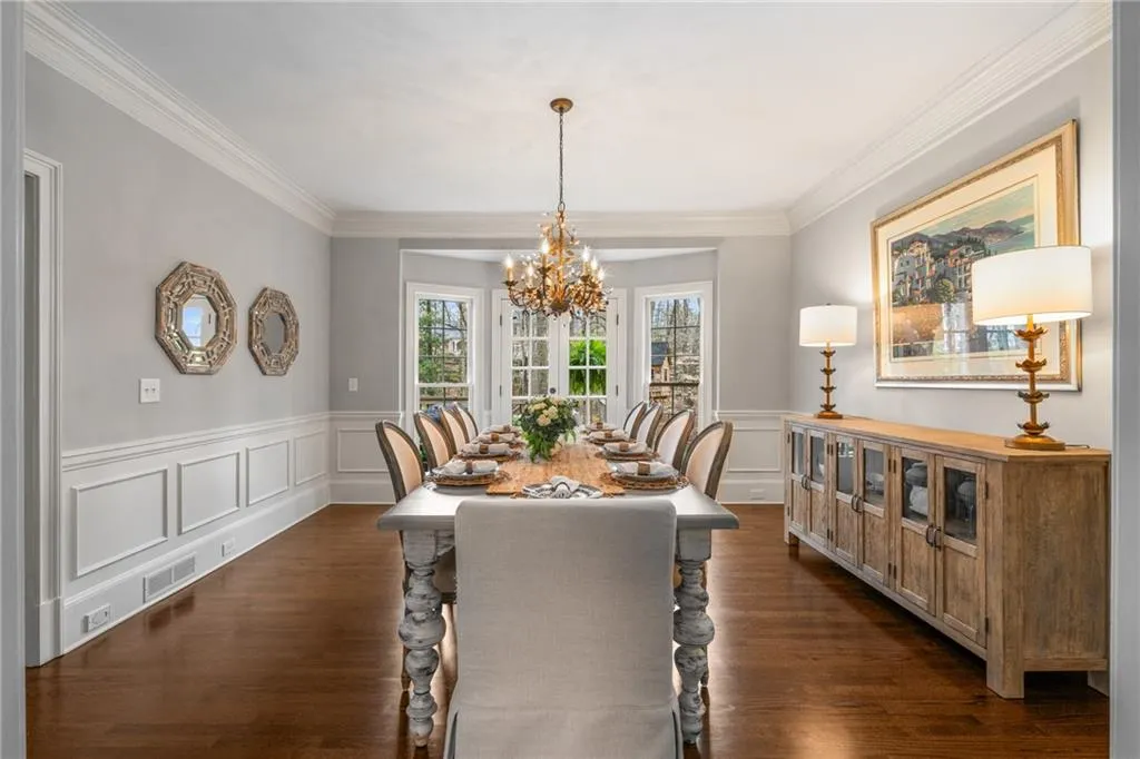 Dining room featuring dark wood finished floors, visible vents, crown molding, and an inviting chandelier