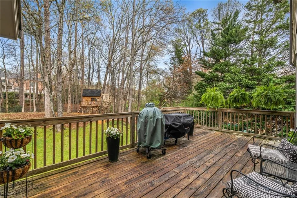 Wooden terrace with a lawn and area for grilling
