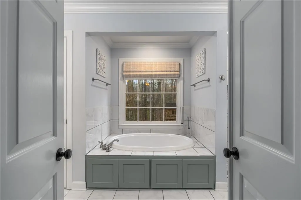 Bathroom with a bath and crown molding