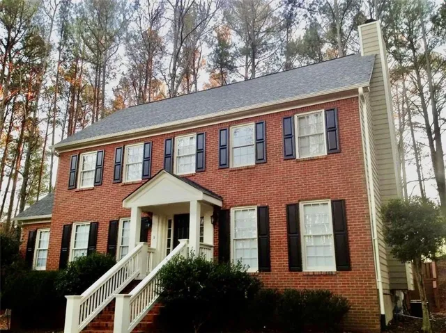 Brick exterior with a gabled roof and black window shutters