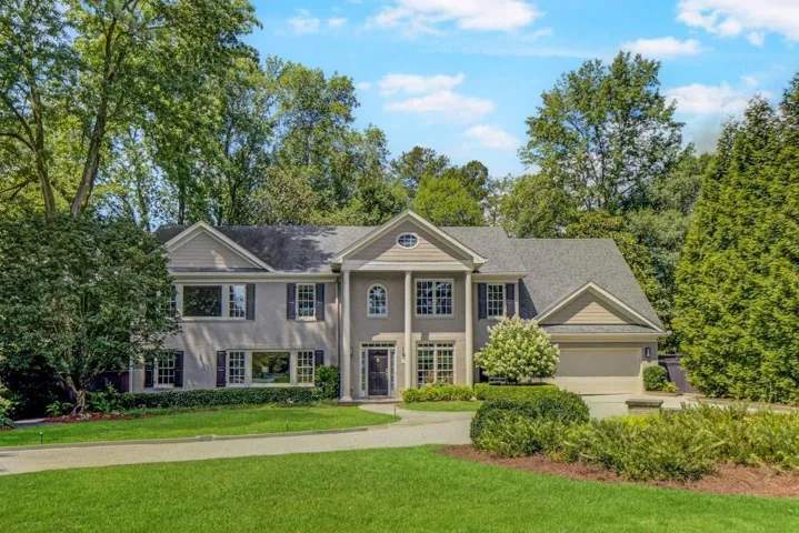 Two-story residence featuring a gray exterior, multiple gables, and a prominent front entrance with columns