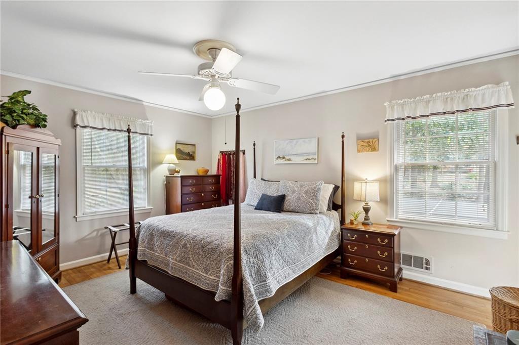 Bedroom with multiple windows, light wood-type flooring, and ceiling fan Bedroom with multiple windows, light wood-type flooring, and ceiling fan