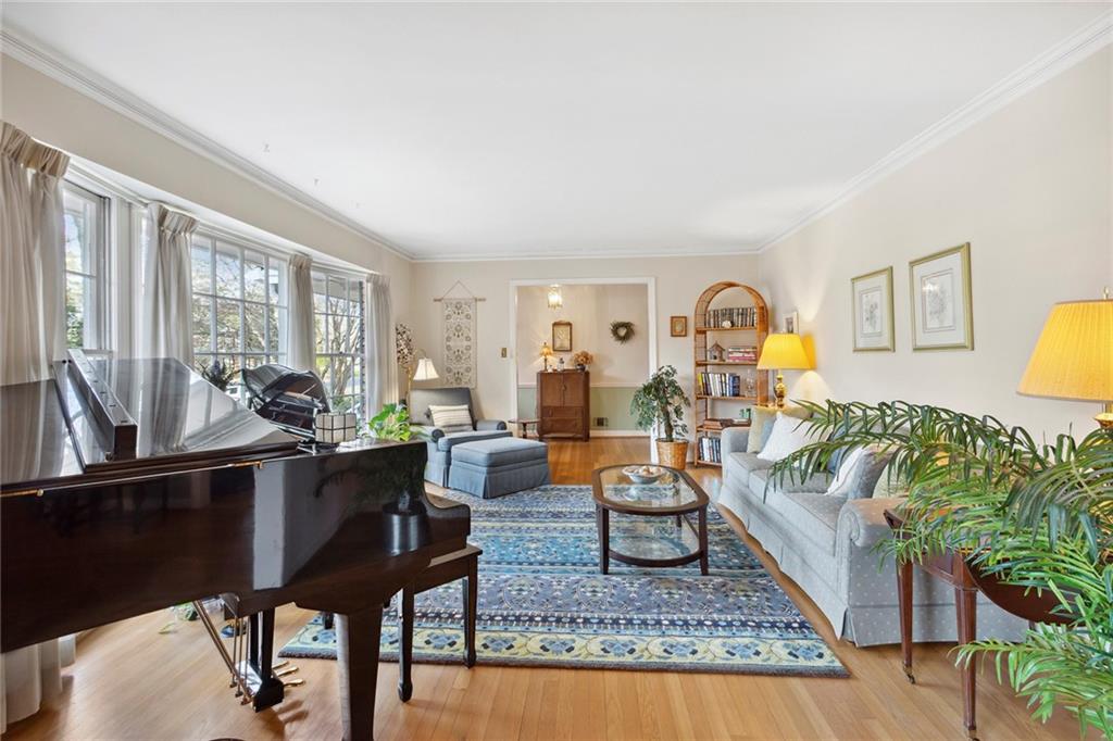 Living room with ornamental molding and light wood-type flooring Living room with ornamental molding and light wood-type flooring